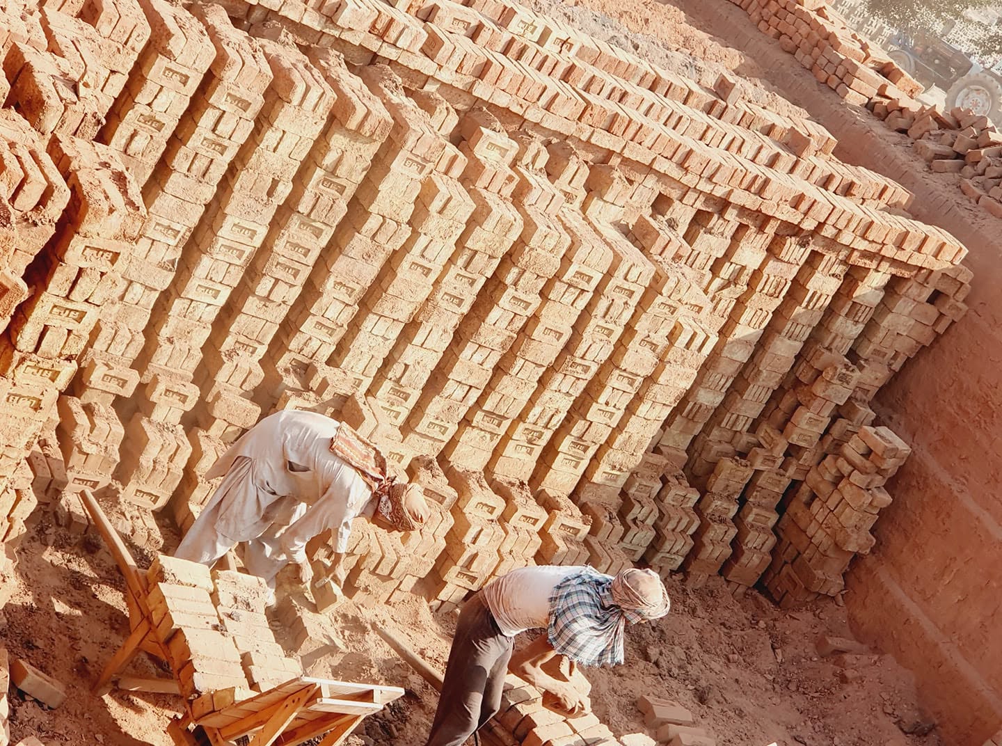 Workers making and stacking bricks